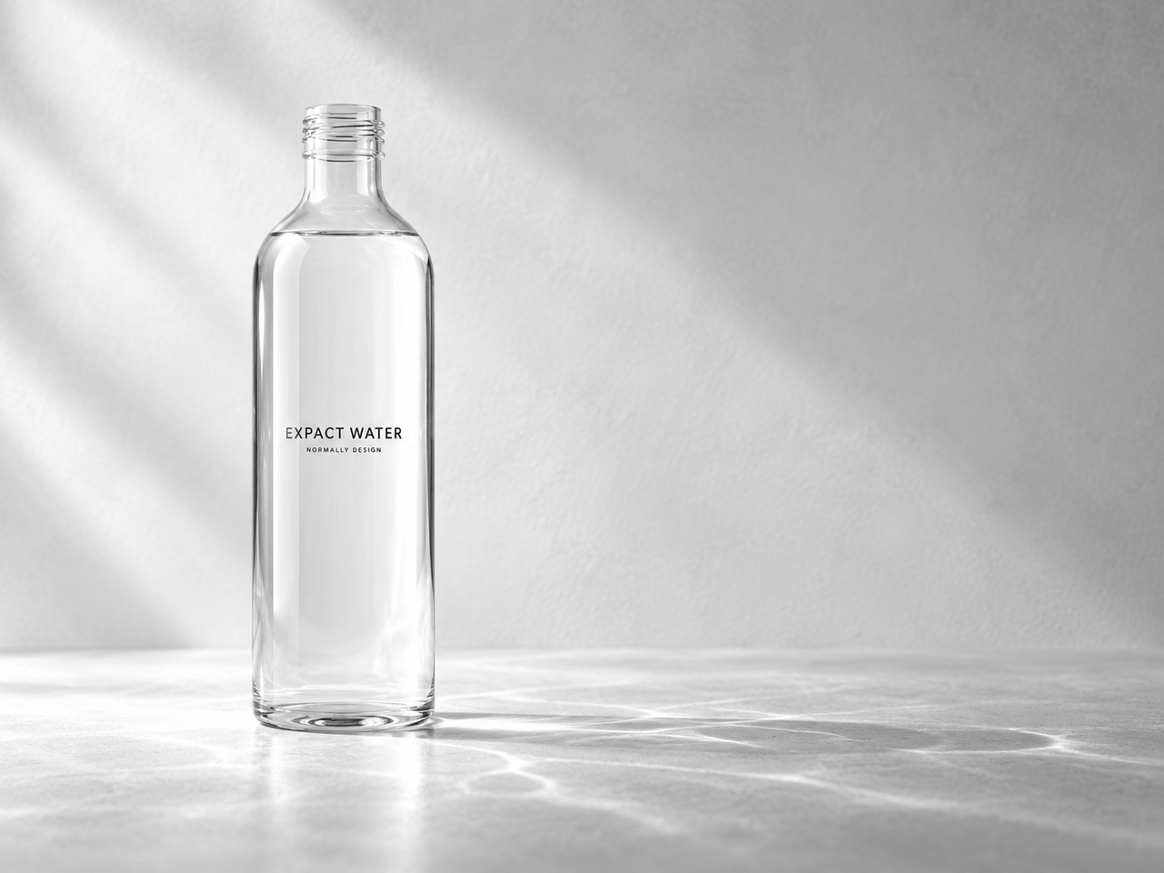 EXPACT WATER. › EXPACT |スタートアップ支援|新たな挑戦に、旗を掲げよう。|Seed Impacts, Harvest Changes.| › Clear glass water bottle standing upright on a light marble surface with soft diagonal shadows; label reads EXPACT WATER. › EXPACT |スタートアップ支援|新たな挑戦に、旗を掲げよう。|Seed Impacts, Harvest Changes.|